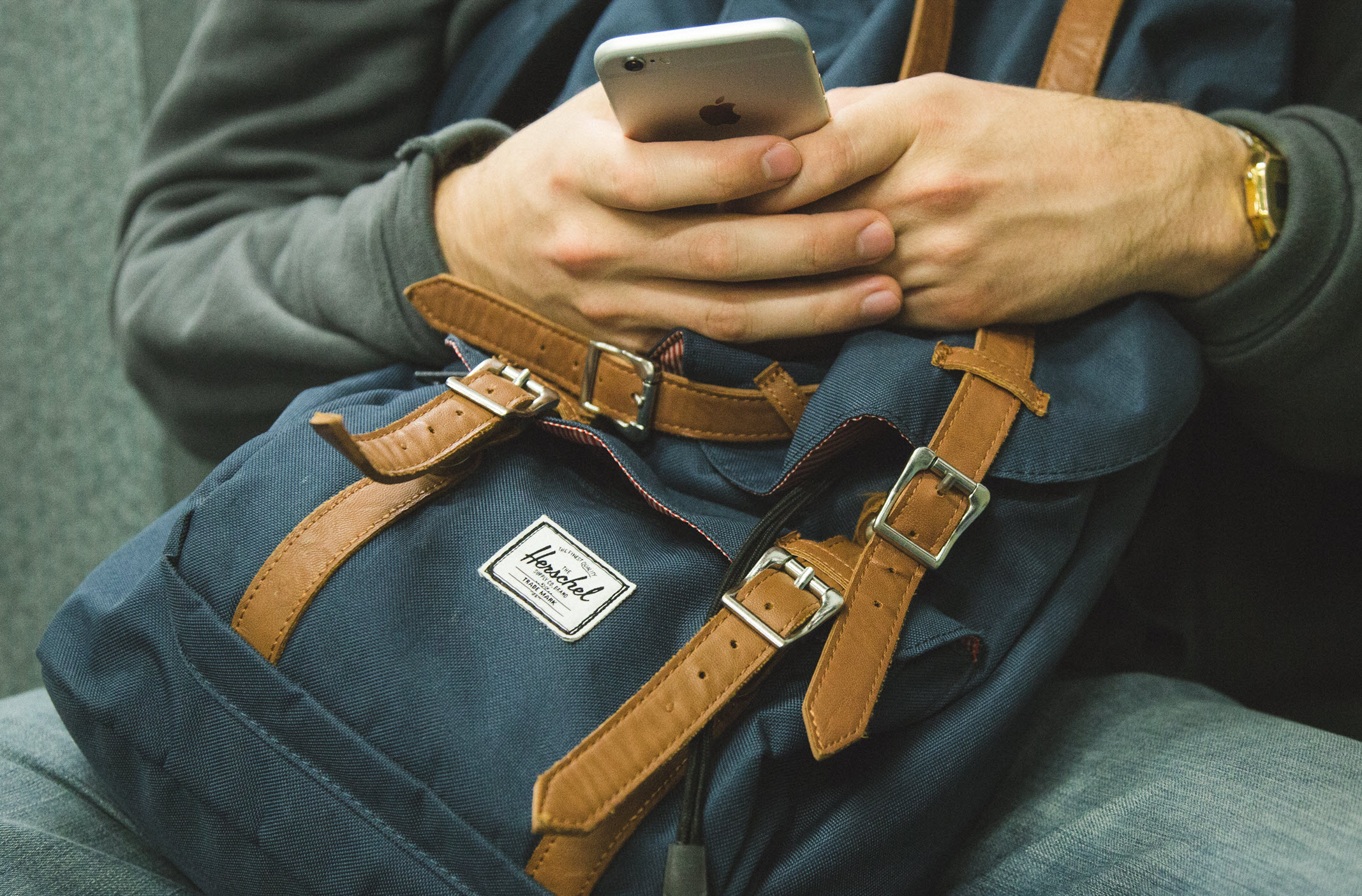 Photo of person with phone and bookbag